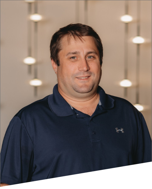 Man in navy shirt with blurred lights background.