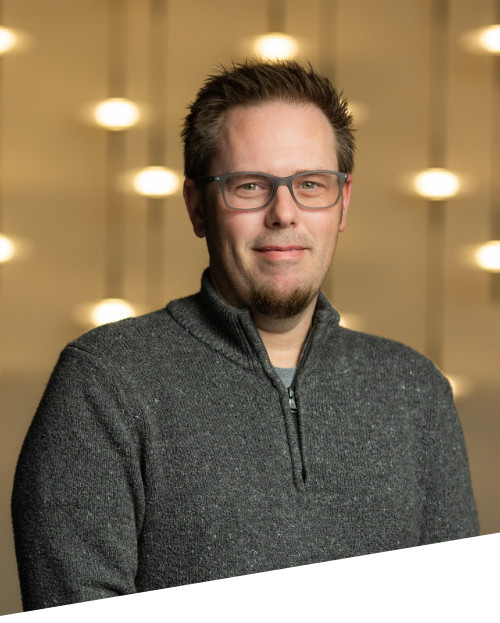 Person smiling against blurred light background.