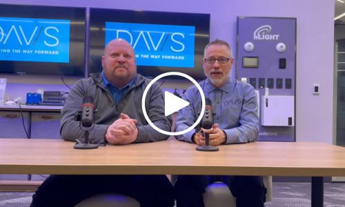 Two men speaking in a tech office setting.