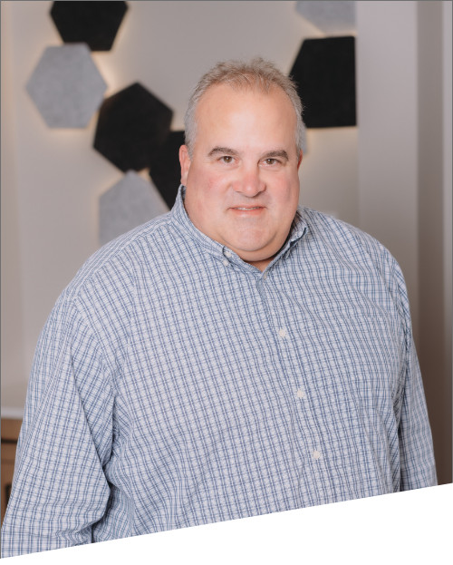 Person in checkered shirt smiling indoors.