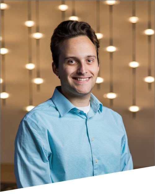 Person in blue shirt with decorative background lights.