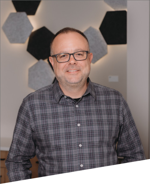 Man in plaid shirt with hexagon wall decor