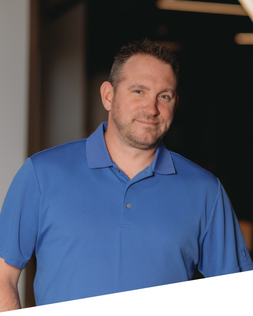 Man in blue polo shirt smiling.