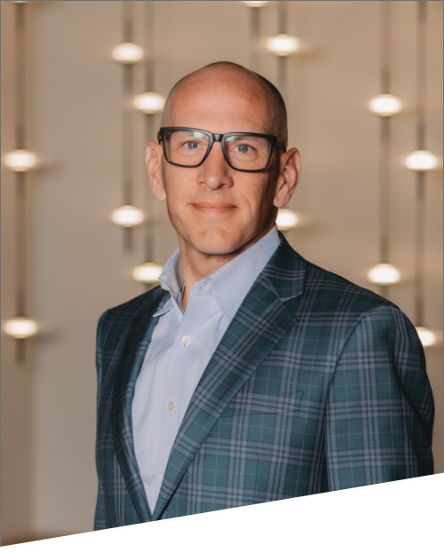 Man in suit with glasses smiling indoors