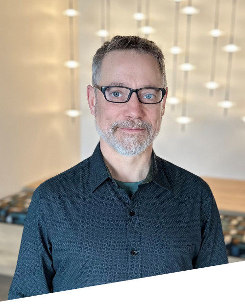 Man with glasses in modern room setting.