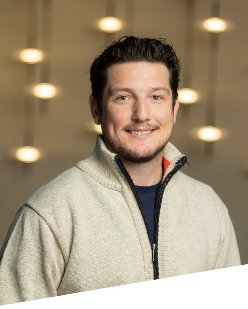 Smiling man in sweater with blurred lights background